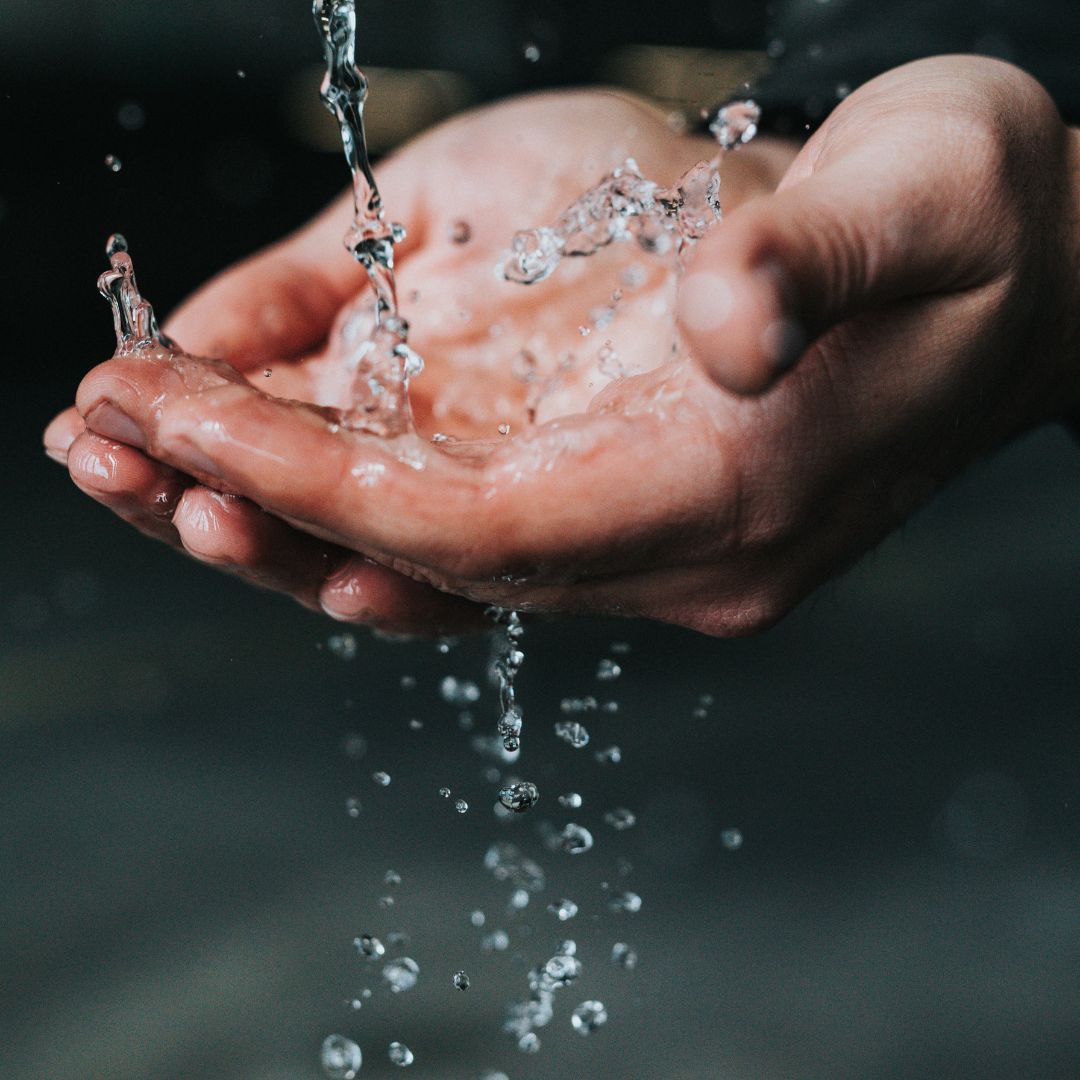 photo image of two hands outstretched catching clean water from above